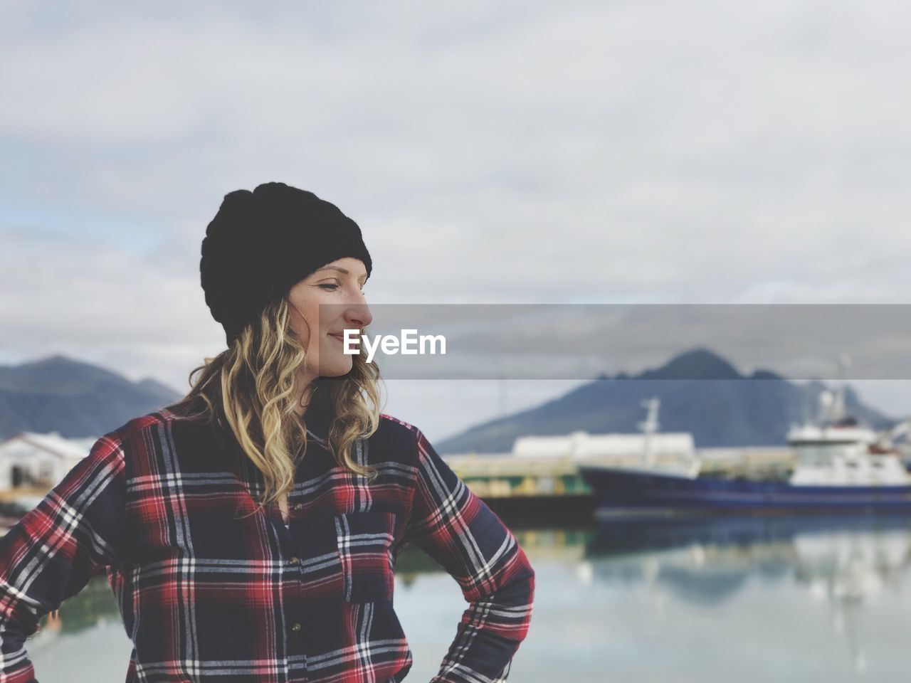 Young woman standing against dock