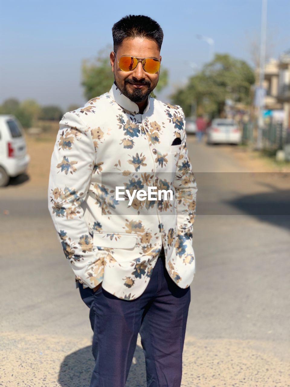 Portrait of well-dressed man standing on road