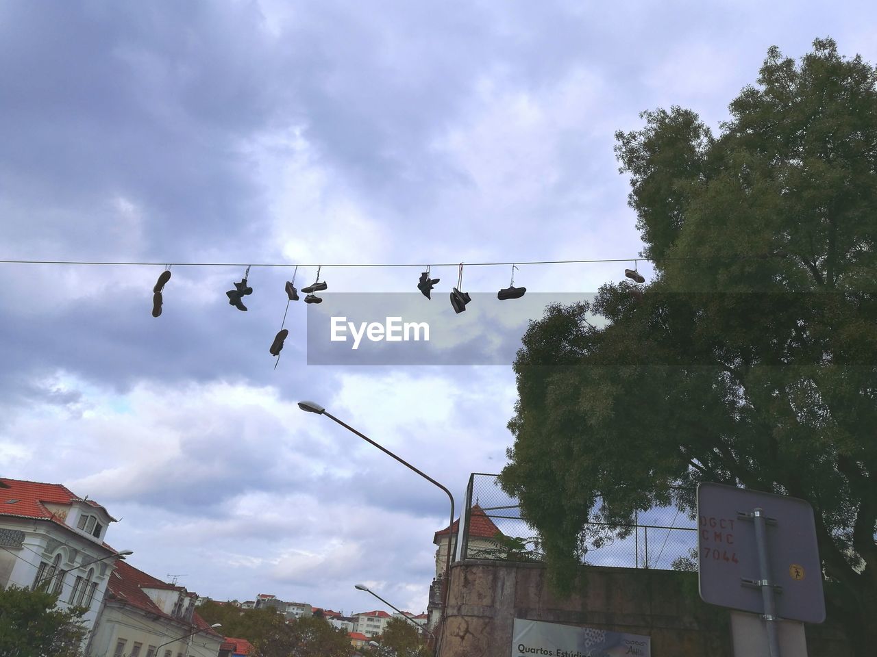 Low angle view of shoes hanging on string against sky