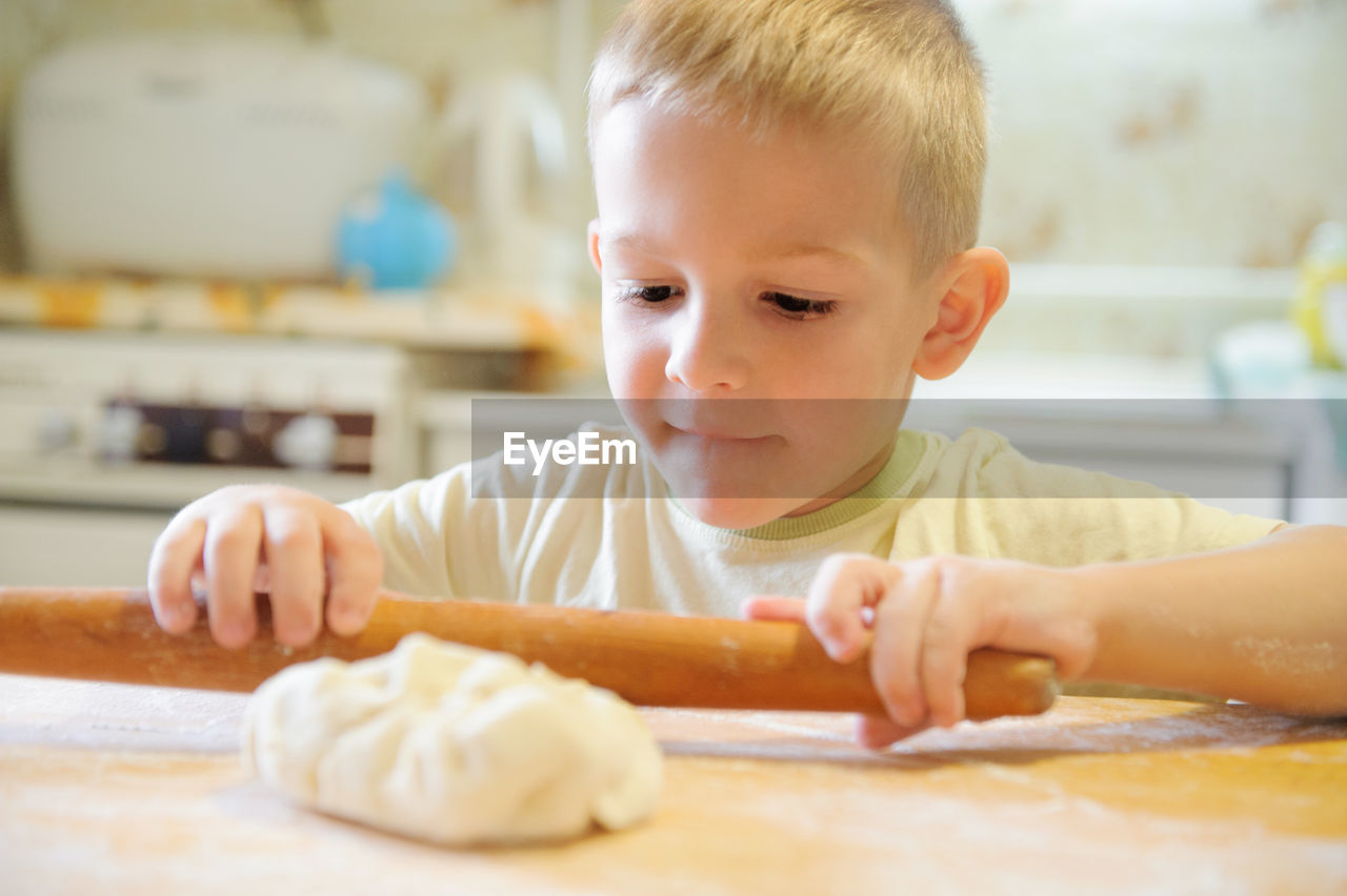 Close-up portrait of boy eating food on table