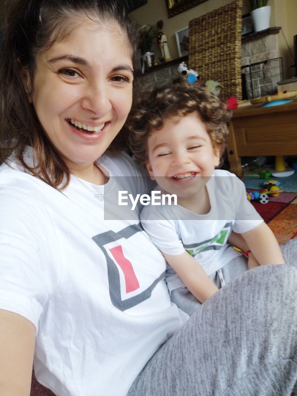 PORTRAIT OF SMILING BOY AND WOMAN AT HOME