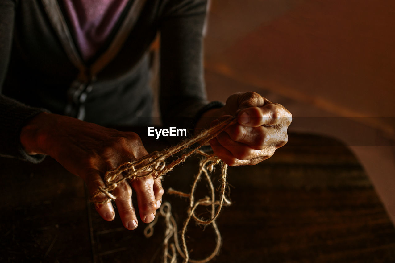 Hands of old woman with polyarthritis disease. canvas strings on fingers of elderly lady, puppets