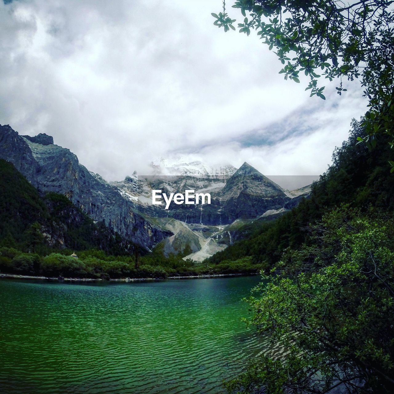 Scenic view of river and mountains against cloudy sky