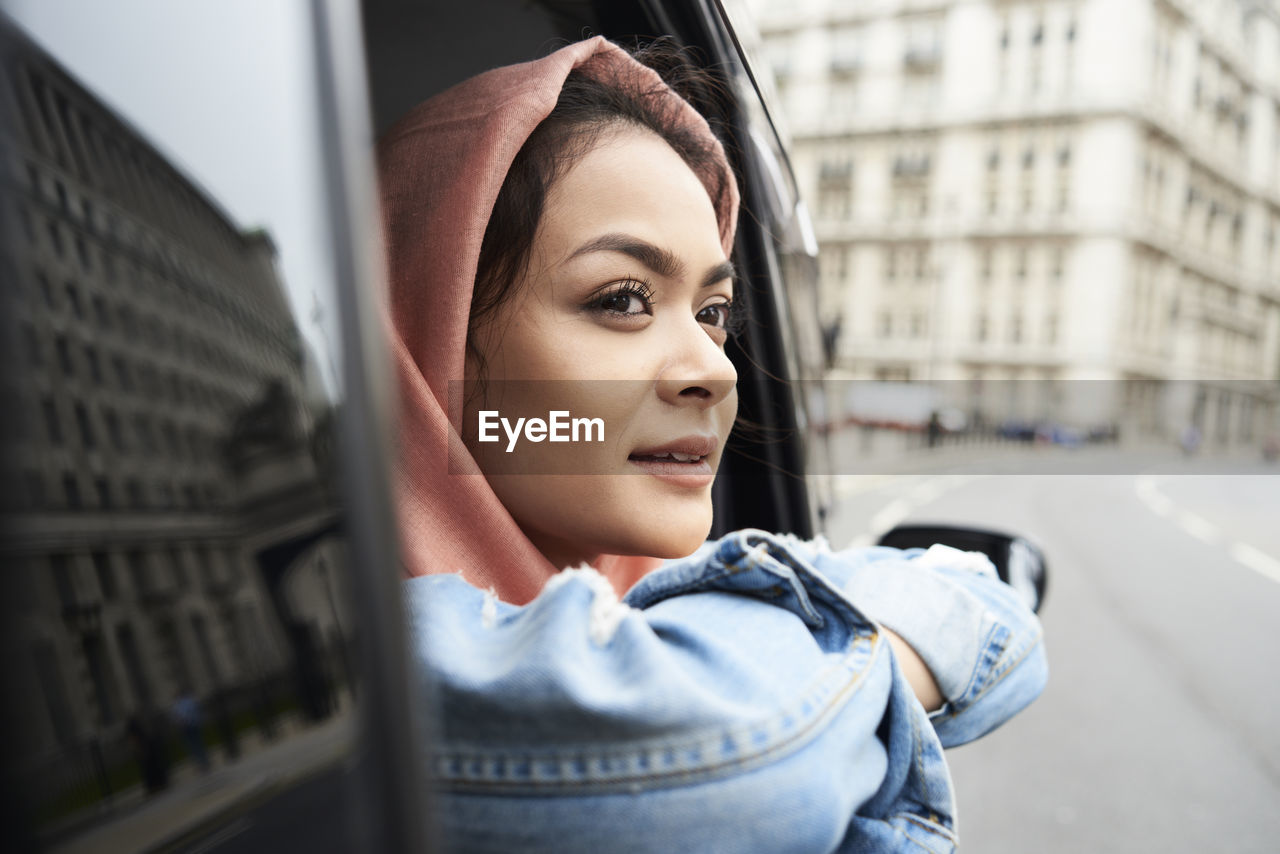 Uk, england, london, young woman wearing hijab looking out of a taxi