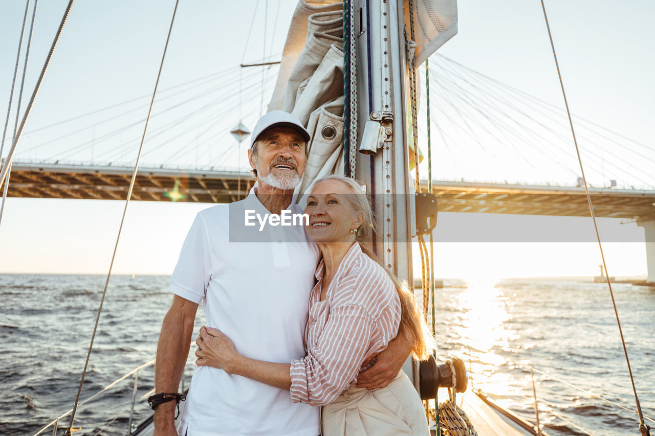 Senior couple on boat at sea against sky