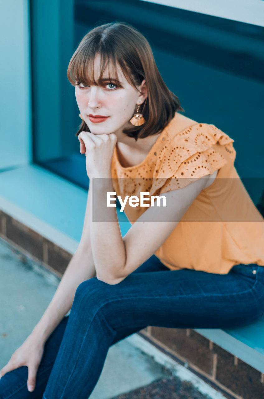 Portrait of beautiful young woman sitting outdoors