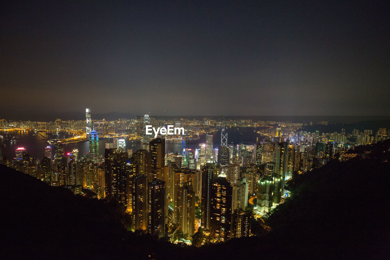 Illuminated cityscape against sky at night