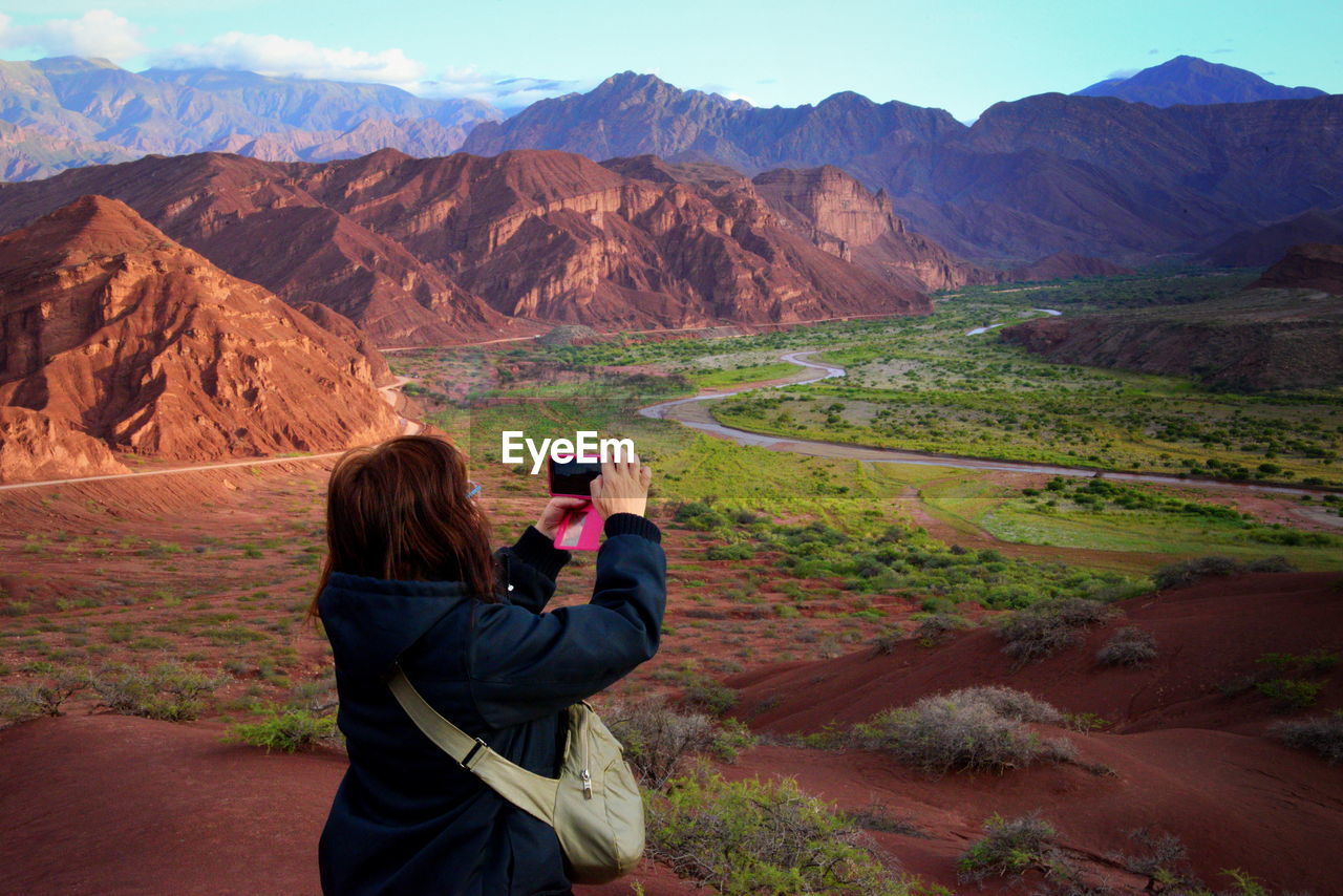 Rear view of woman photographing landscape