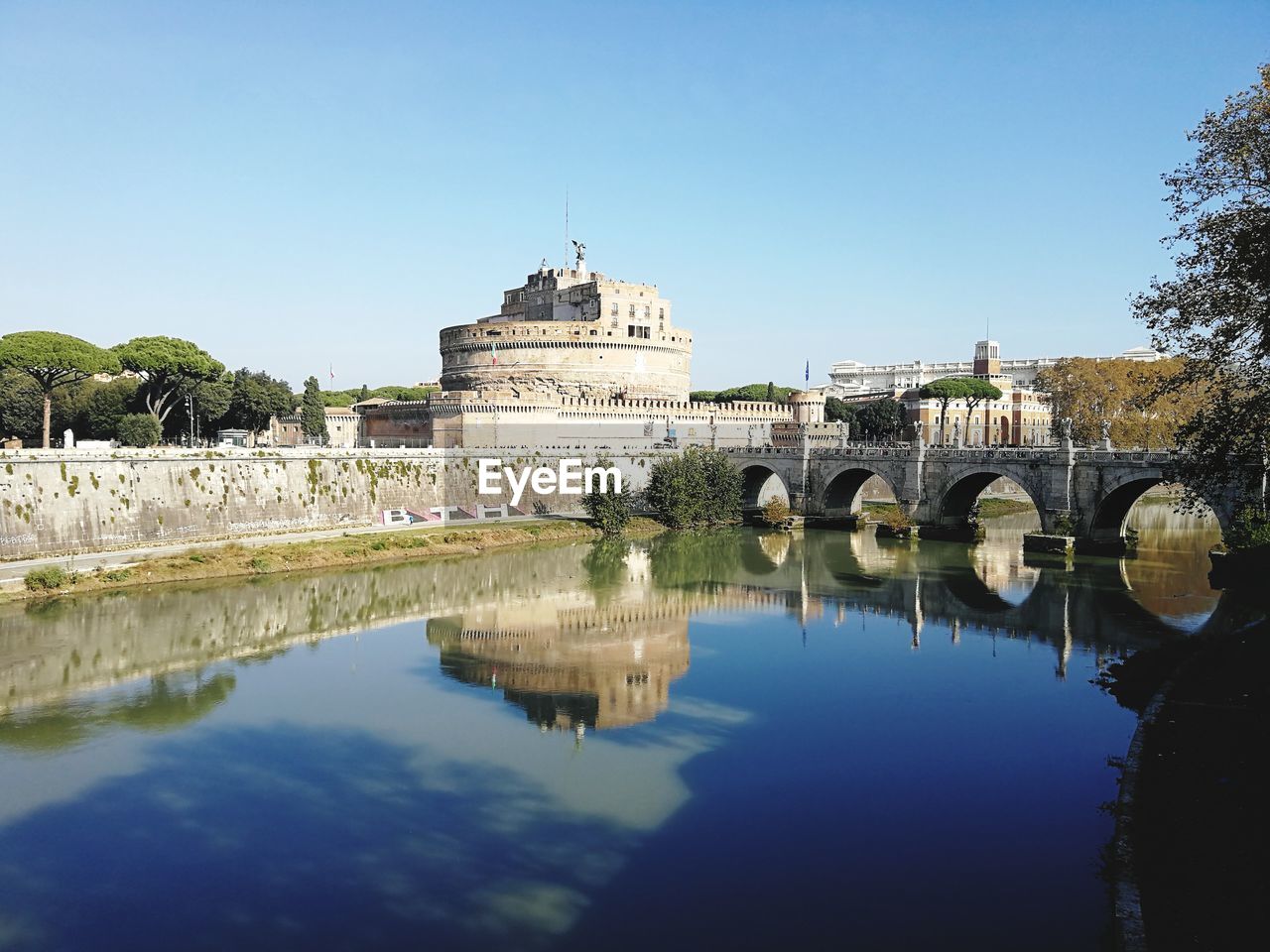 ARCH BRIDGE OVER RIVER AGAINST BUILDING