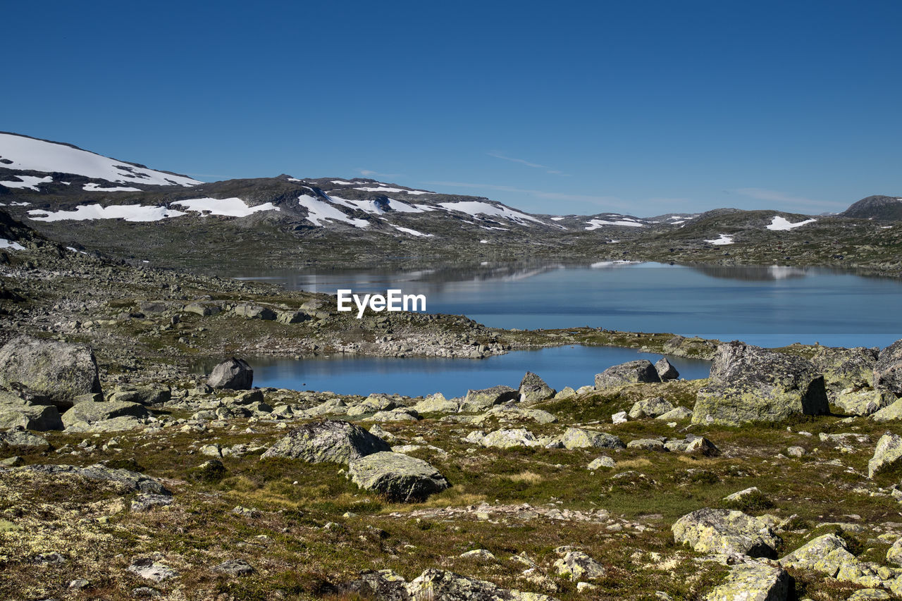 Scenic view of lake against clear blue sky