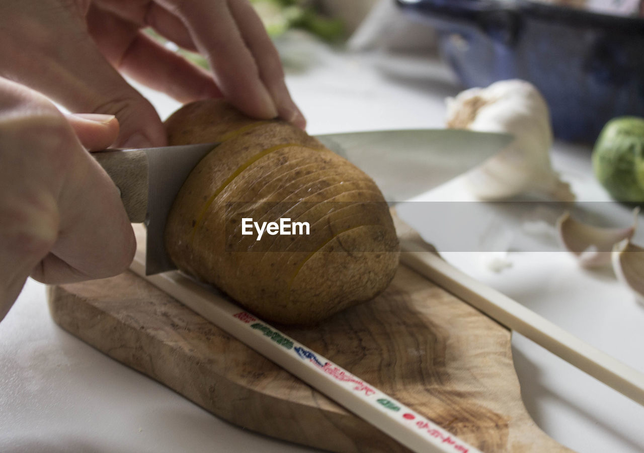 View of person slicing potatoes