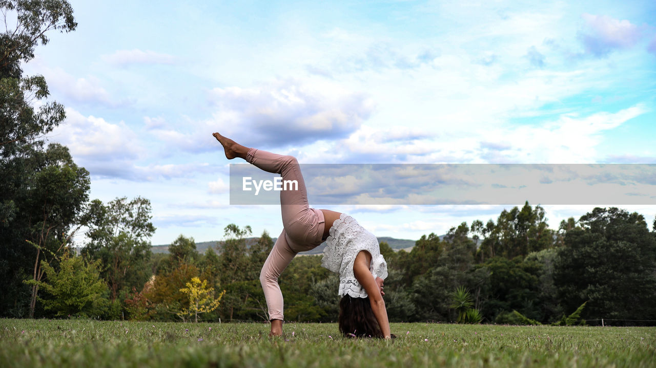 Full length of man with arms raised against sky