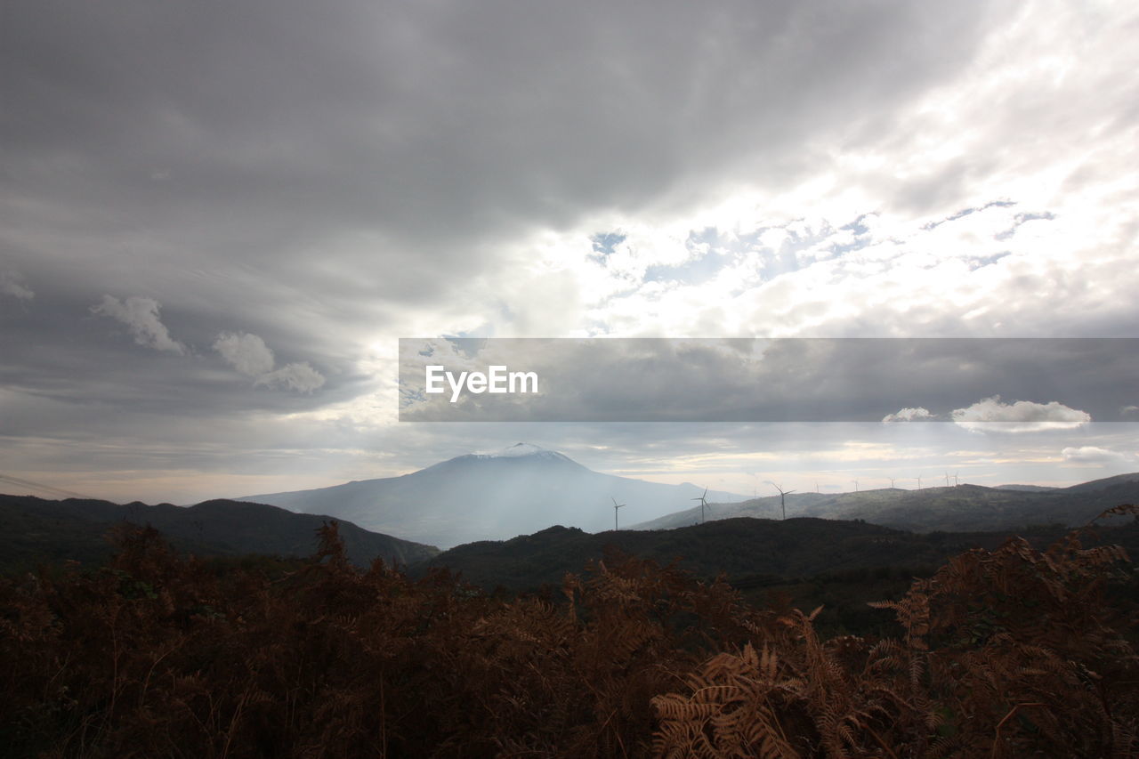 SCENIC VIEW OF MOUNTAINS AGAINST STORM CLOUDS