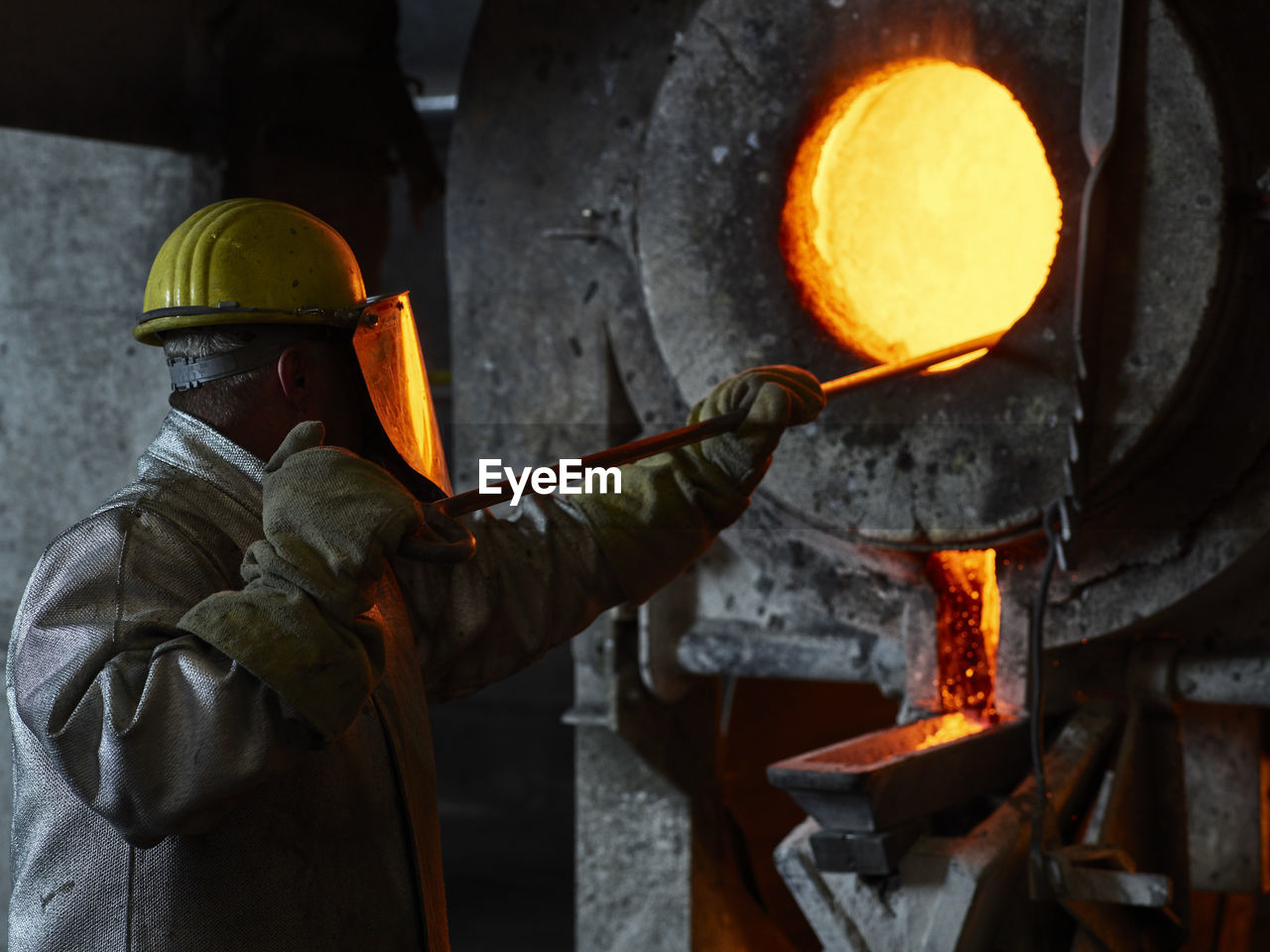 Industry, worker at furnace during melting copper, wearing a fire proximity suit