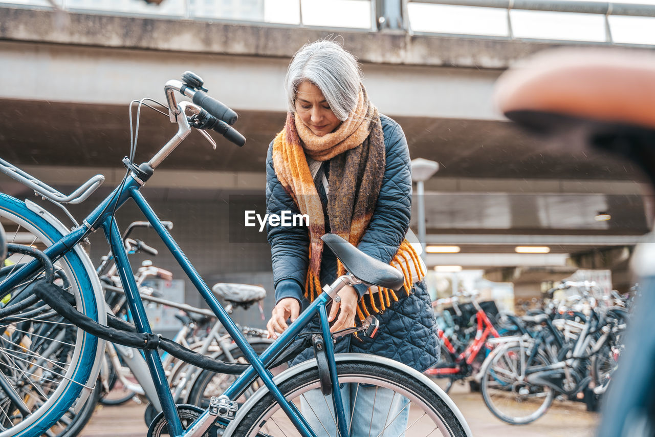 Mature woman renting bicycle at bicycle sharing system