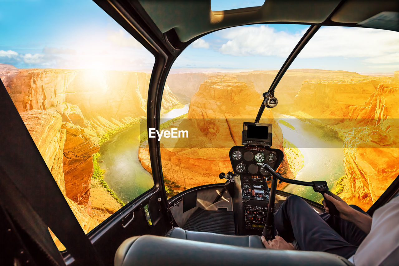 Midsection of man flying helicopter against horseshoe bend