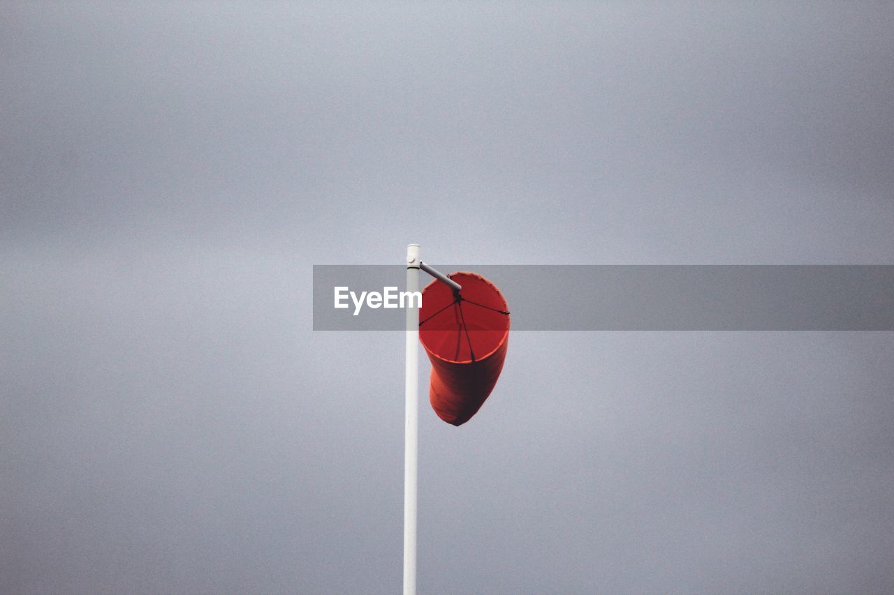 Low angle view of red wind sock against sky