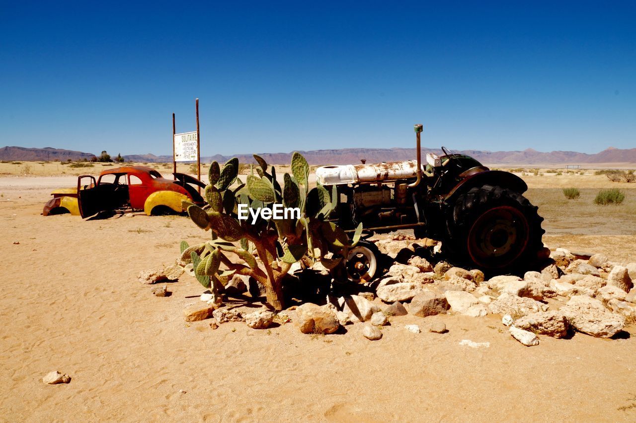 Abandoned car on desert against clear sky