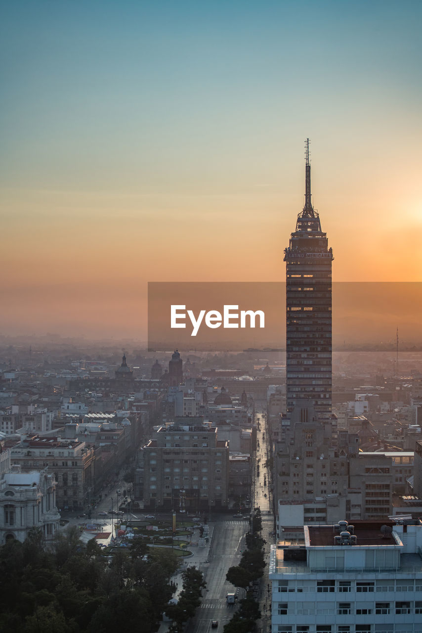 Torre latinoamericana amidst cityscape against sky during sunrise