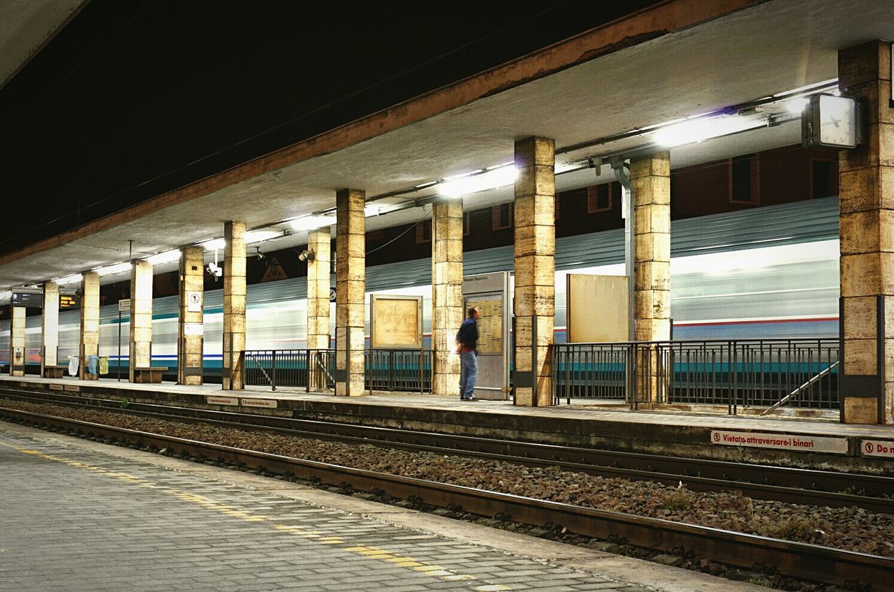 Blurred image of train moving on illuminated railroad station at night