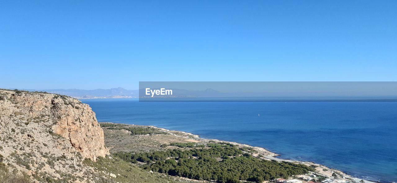 Scenic view of sea against clear blue sky