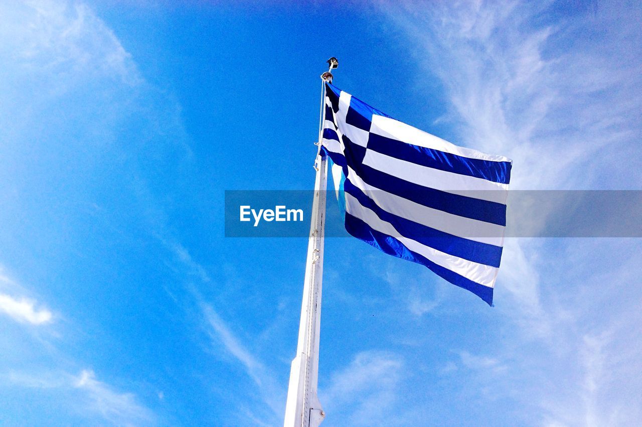 Low angle view of american flag against blue sky