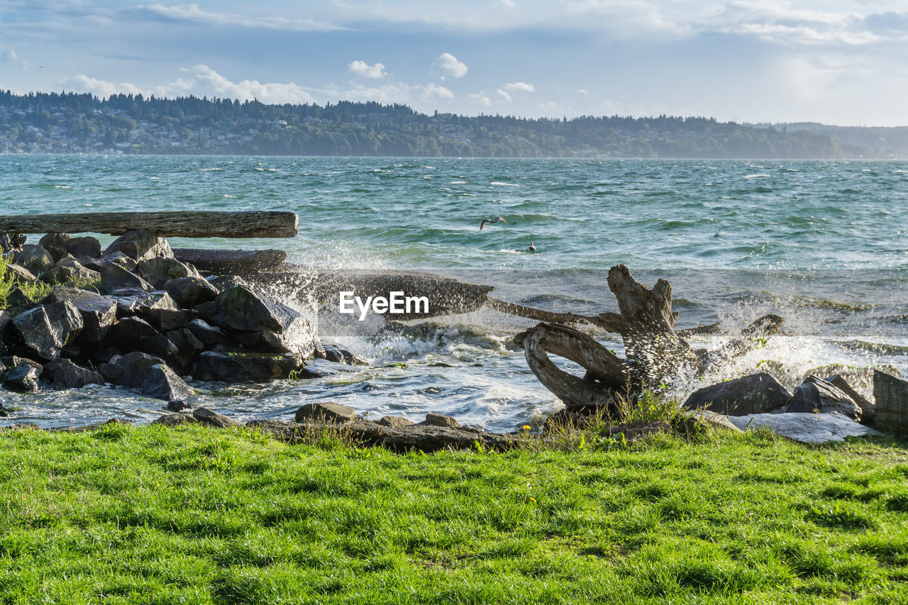 Wave from the puget sound hit rocks on the shoreline in des moines, washington.