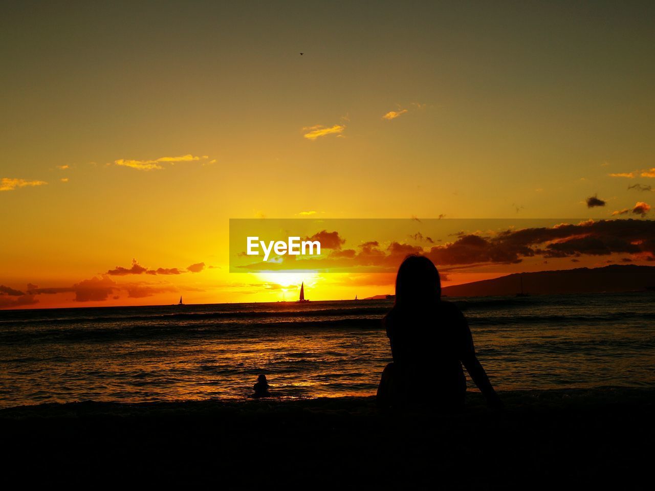 Silhouette of people on beach against sky during sunset