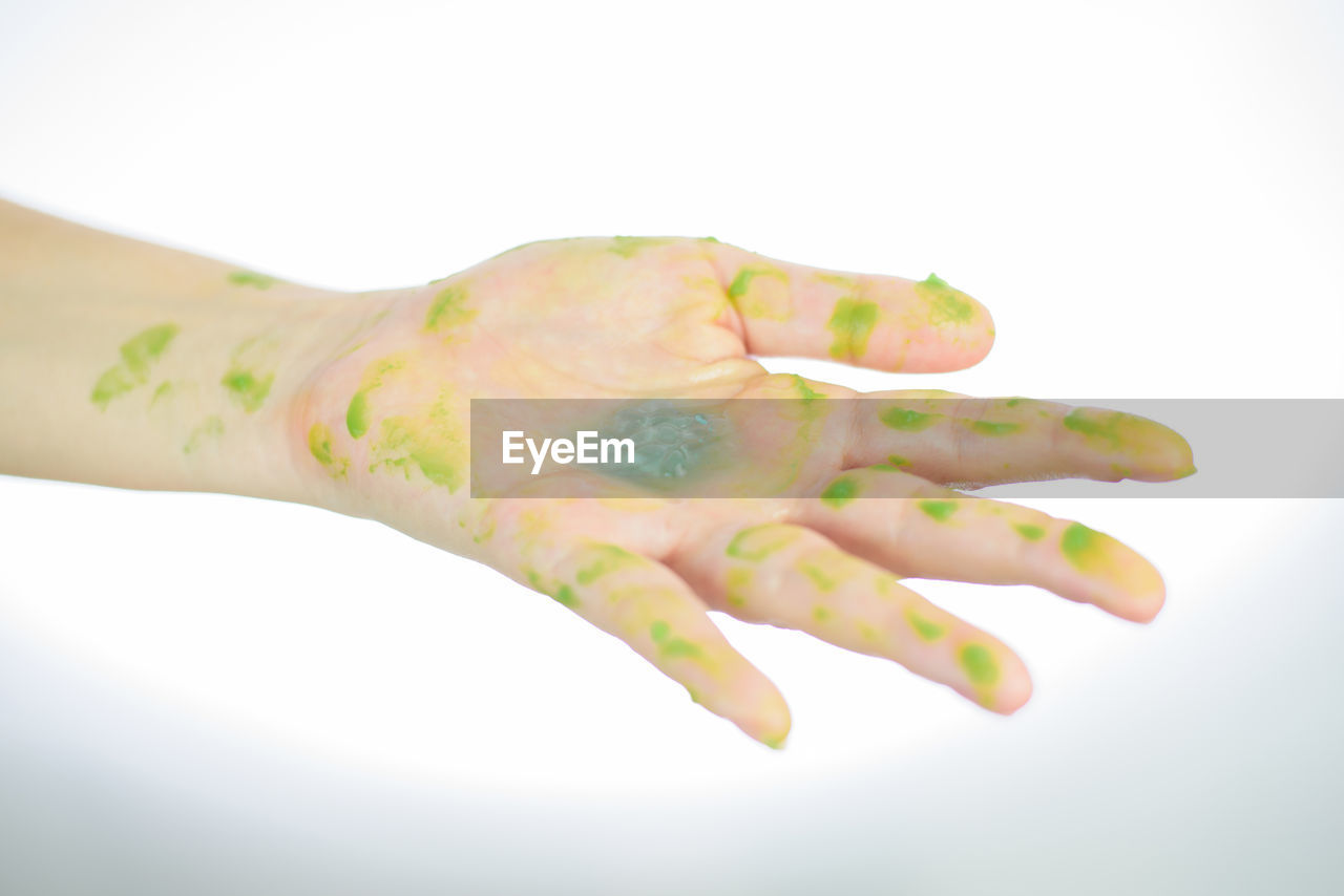 CLOSE-UP OF WOMAN HAND AGAINST GRAY BACKGROUND