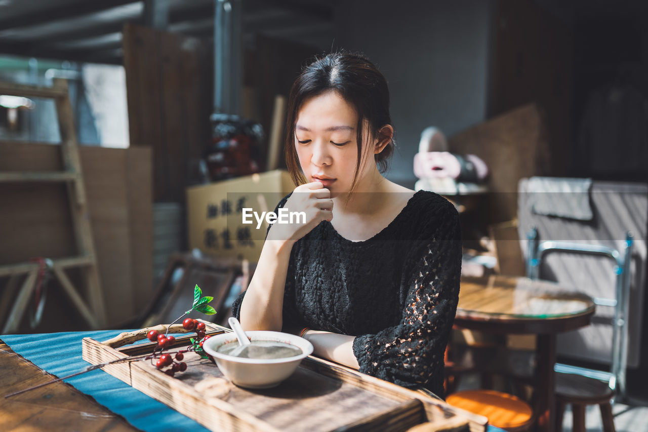 WOMAN SITTING AT TABLE