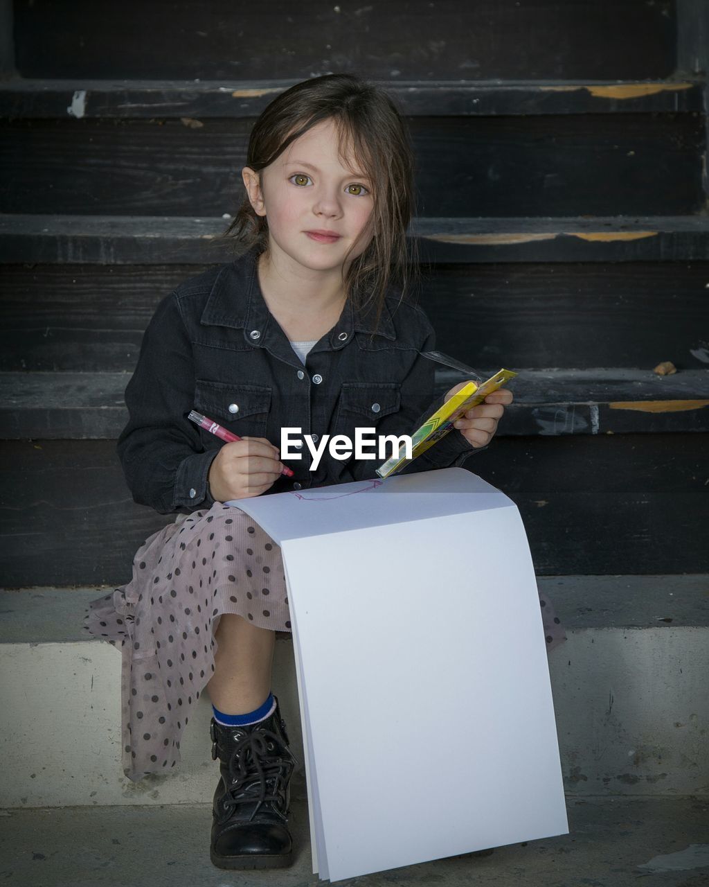 Portrait of smiling girl drawing in book