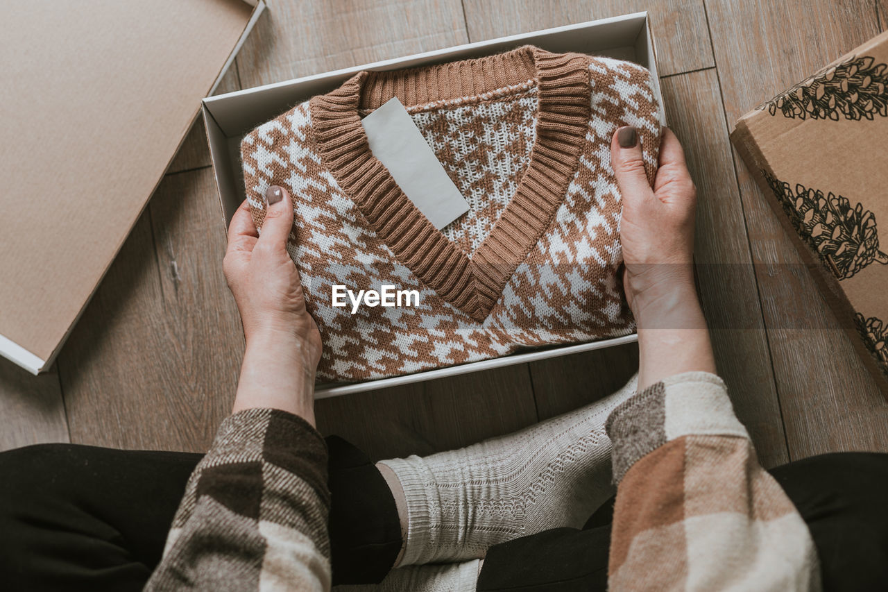 midsection of woman with gift box