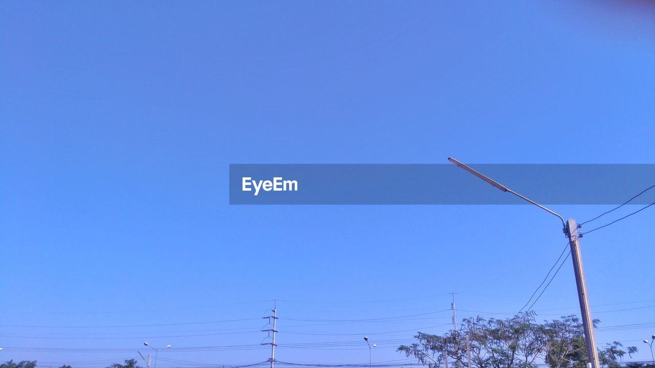 LOW ANGLE VIEW OF ELECTRICITY PYLON AGAINST BLUE SKY