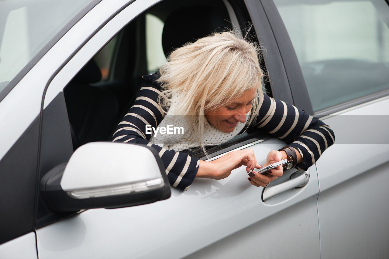 Woman using phone in car