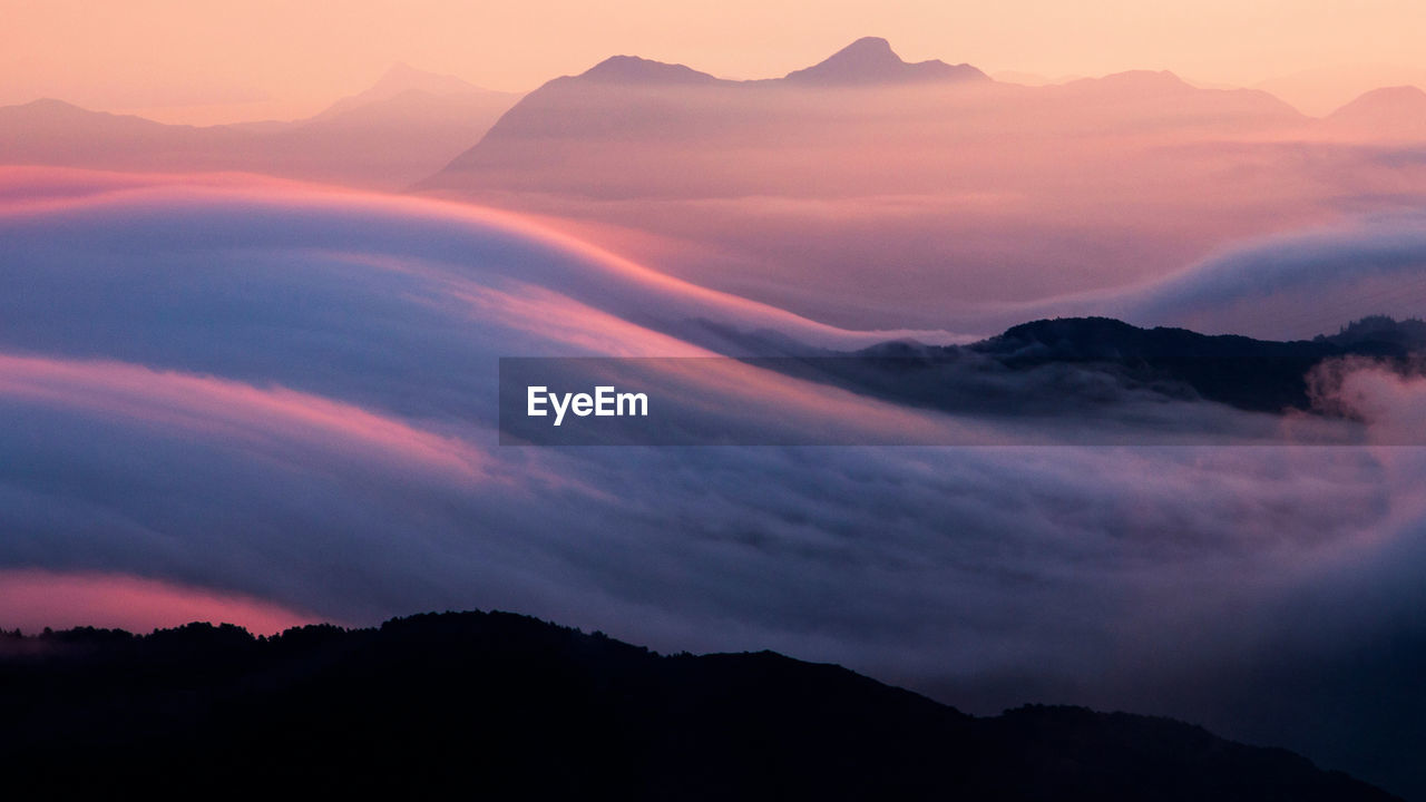 Scenic view of silhouette mountains against sky at sunset