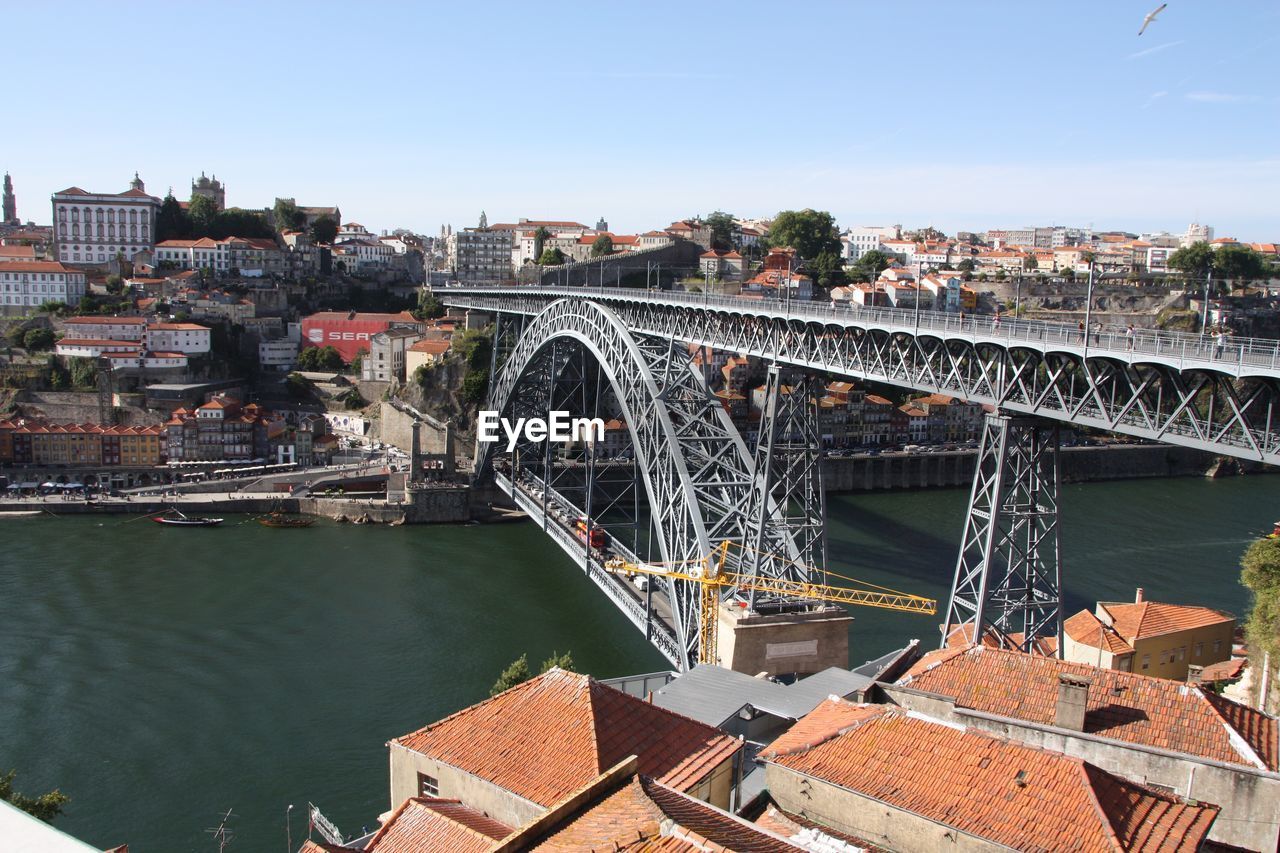 BRIDGE OVER RIVER AGAINST BUILDINGS IN CITY