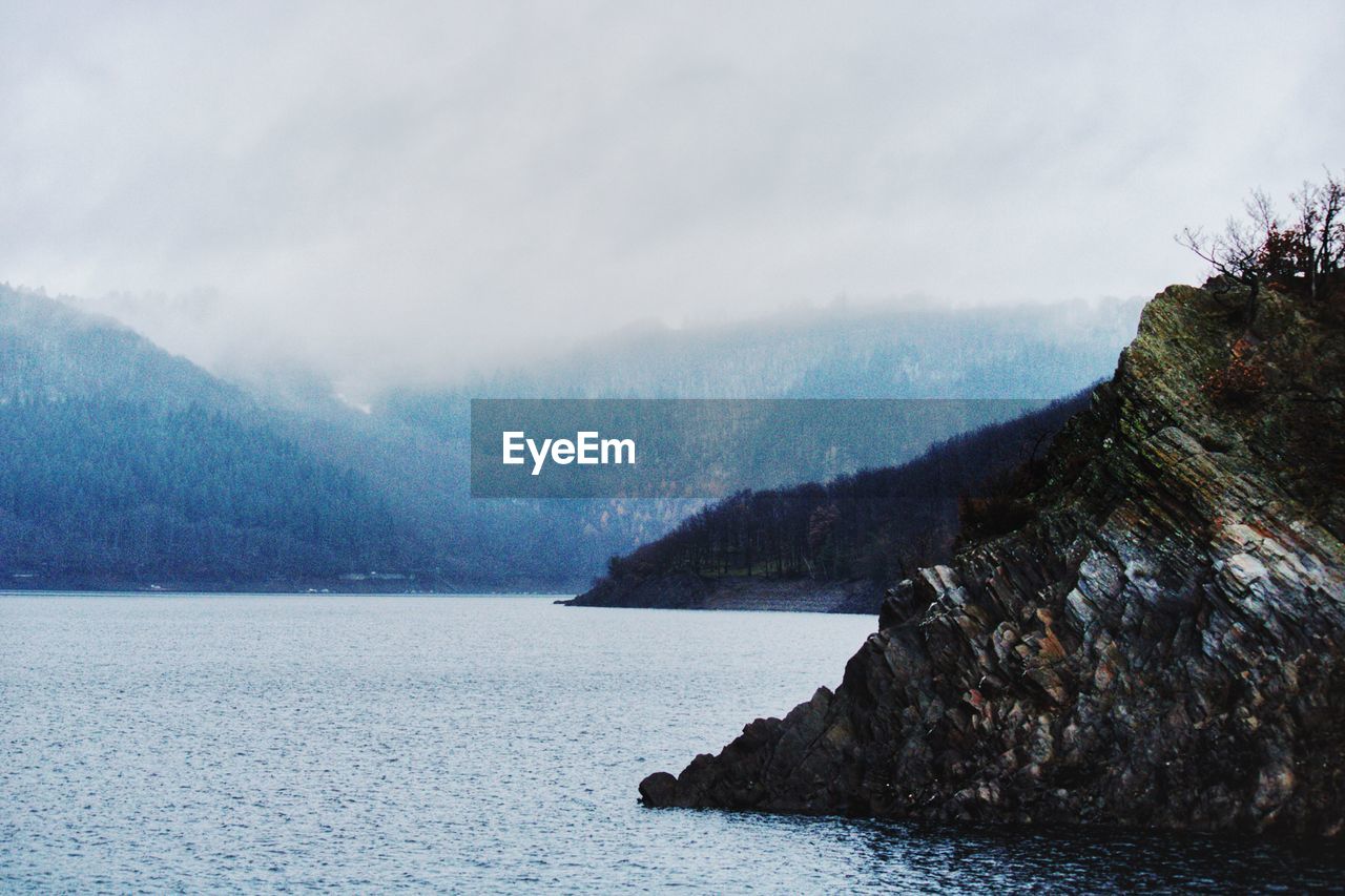 SCENIC VIEW OF SEA BY MOUNTAIN AGAINST SKY