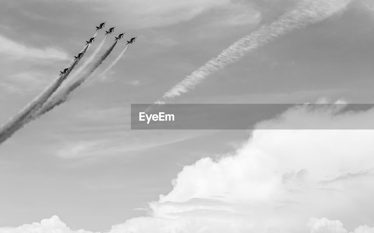 Low angle view of airshow against sky