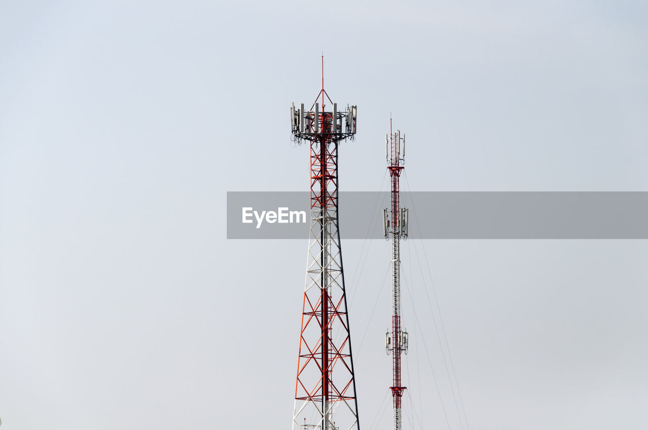 Low angle view of communication towers against clear sky