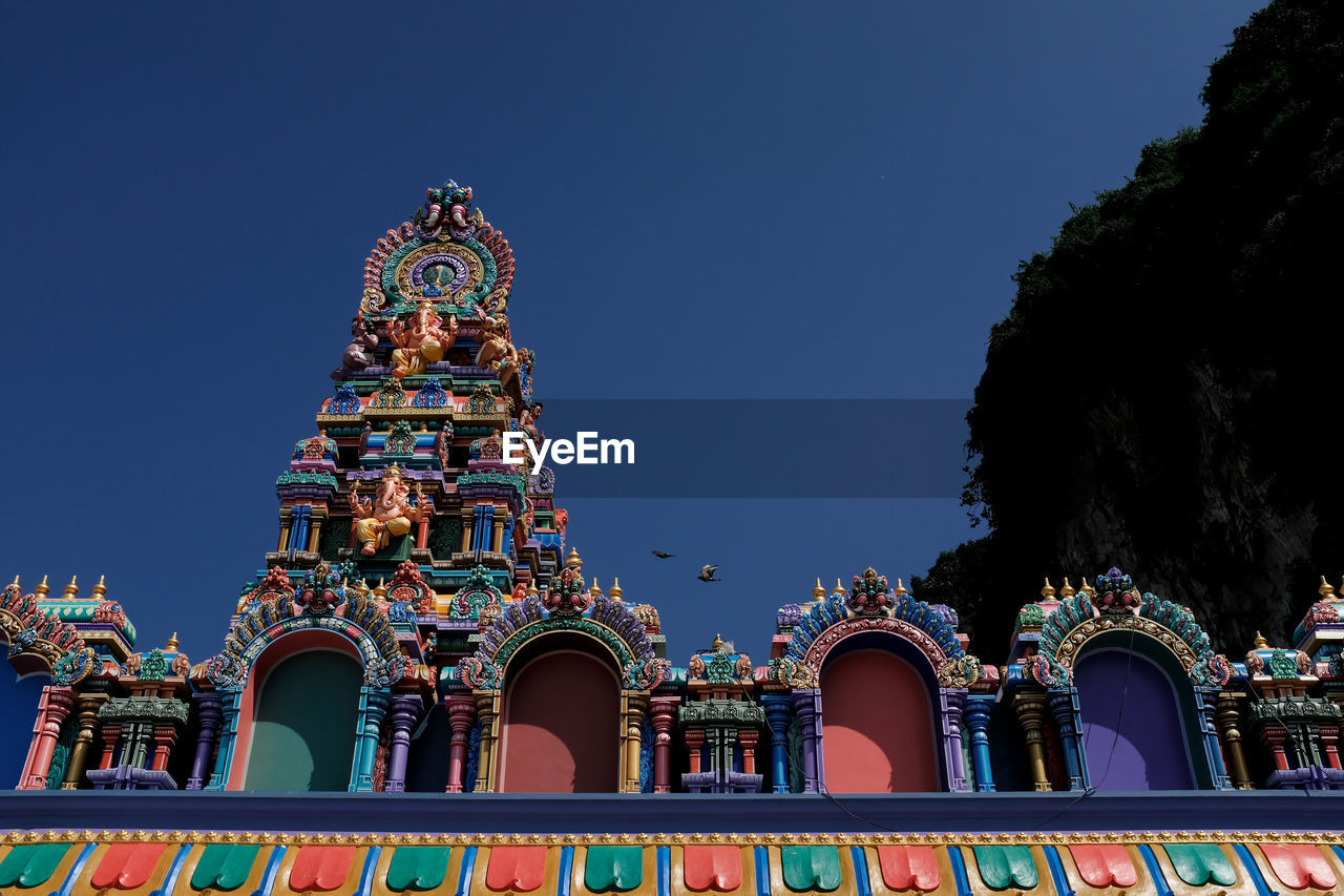 Low angle view of temple building against clear blue sky