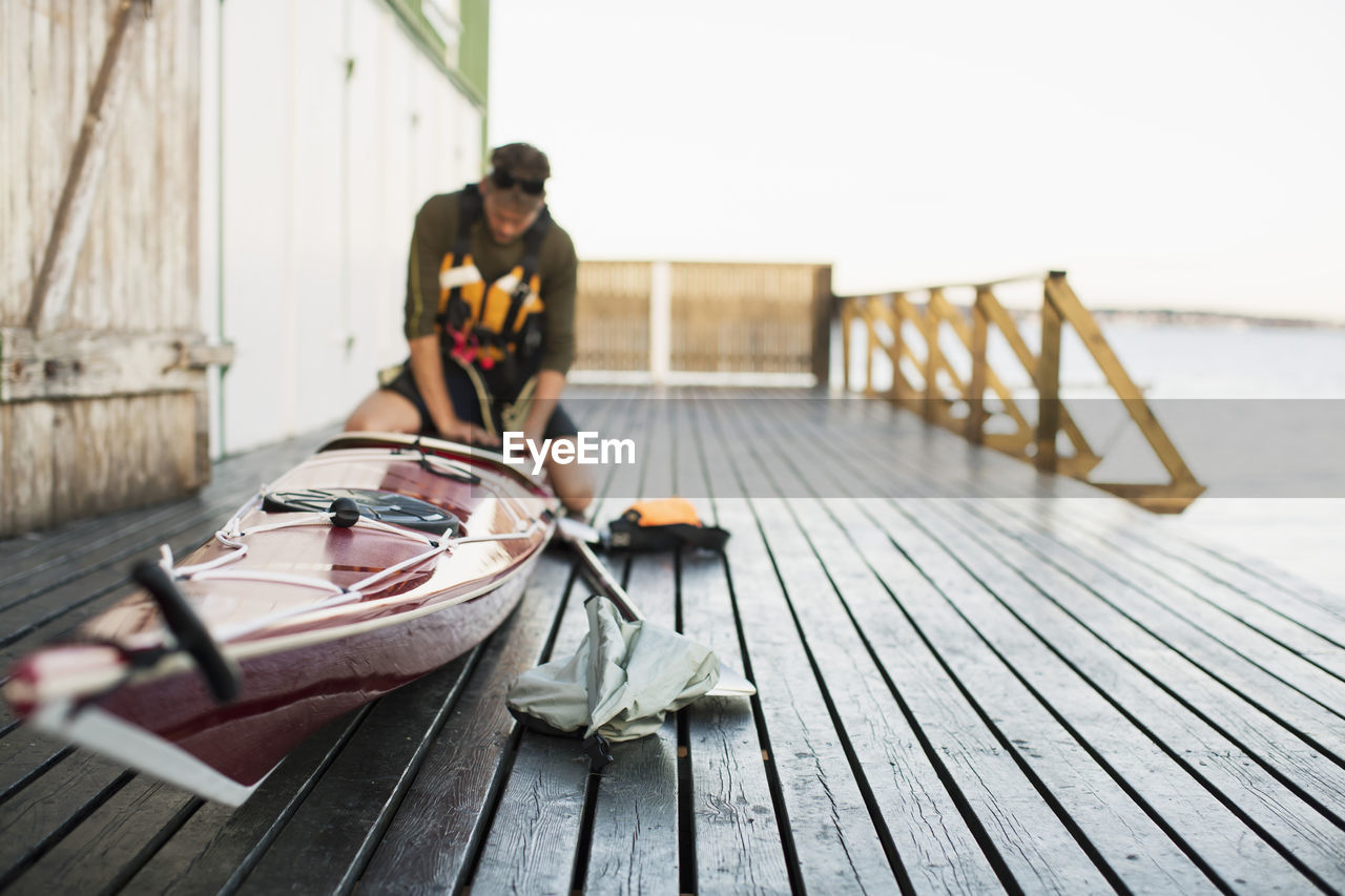 Man preparing kayak on houseboat