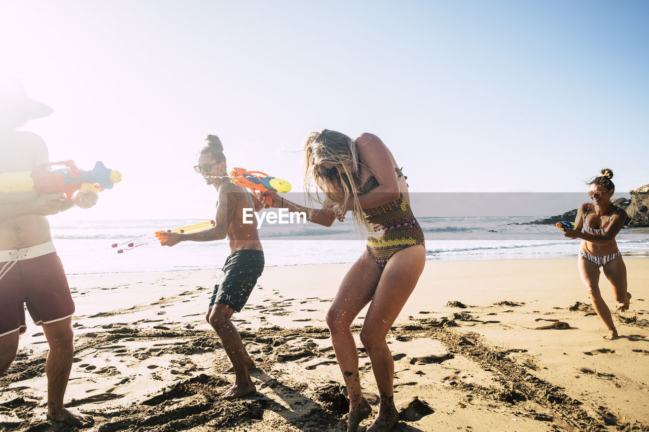 Happy friends enjoying on shore at beach