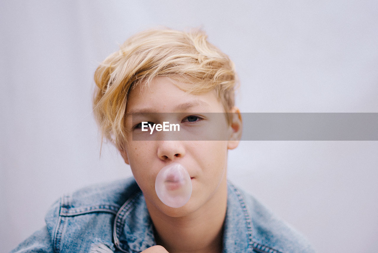 Portrait of young man with eyes closed against wall