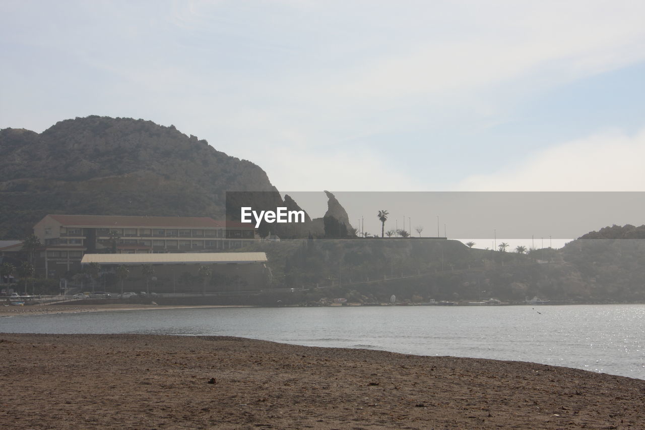 SCENIC VIEW OF BEACH BY MOUNTAINS AGAINST SKY