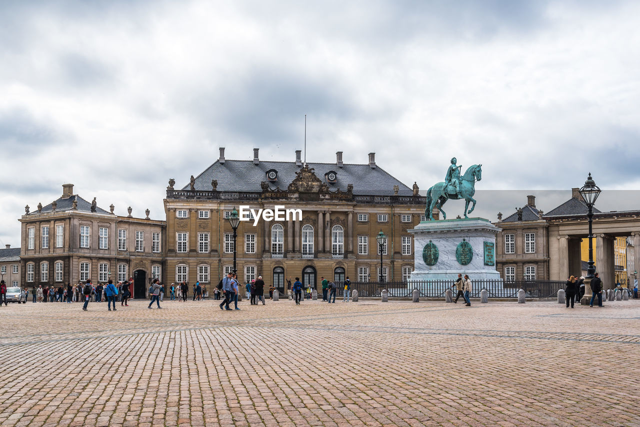 Walkway and historical building against cloudy sky