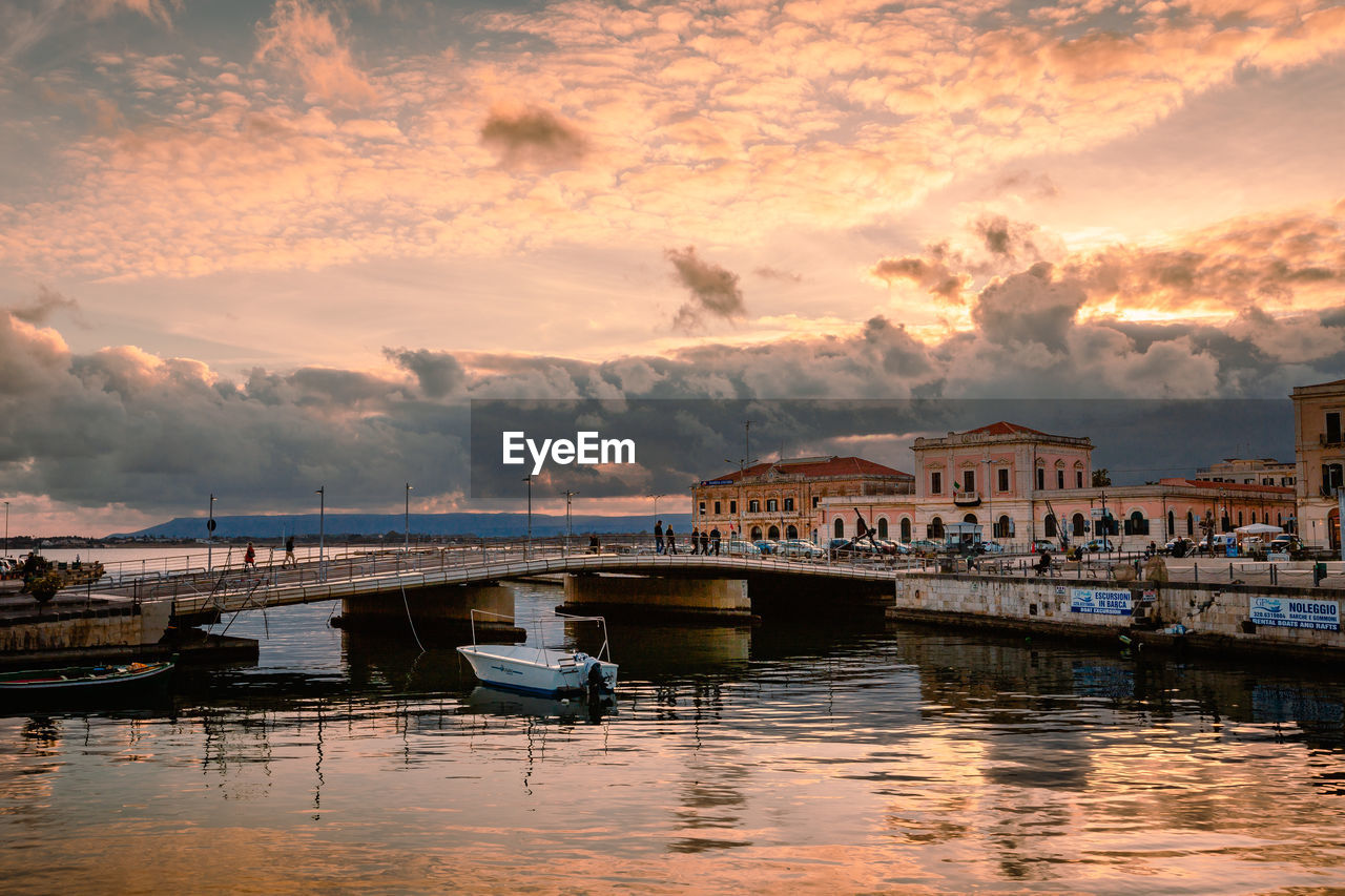 Port of ortigia with boats moored during spectacular sunset