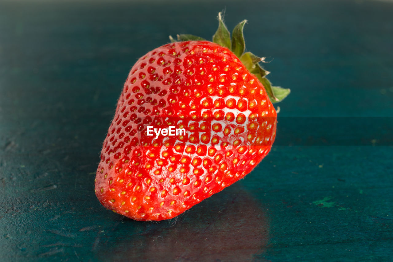 CLOSE-UP OF STRAWBERRY ON APPLE