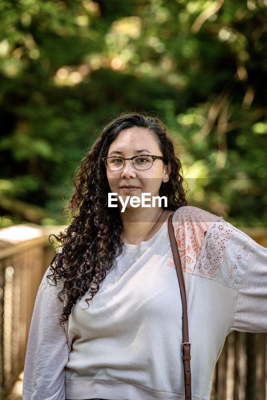 Pretty young woman poses in front of trees and bridges at the capilano suspension bridge