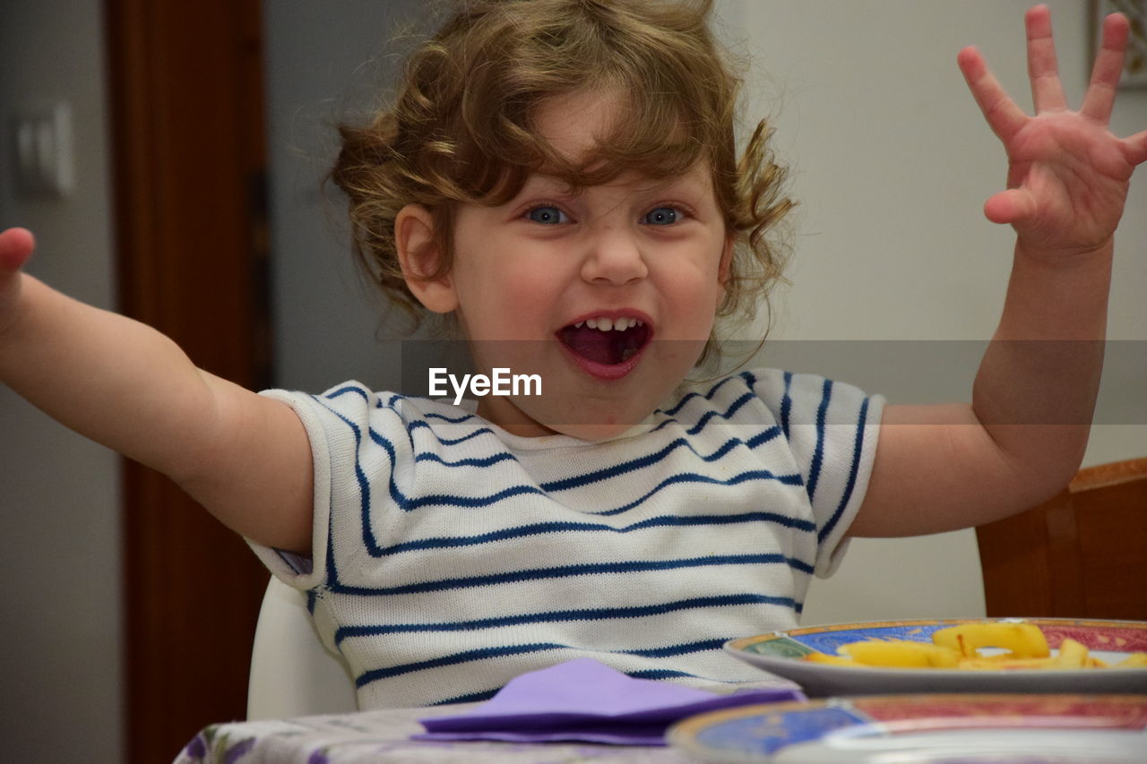 Portrait of cute girl on table at home