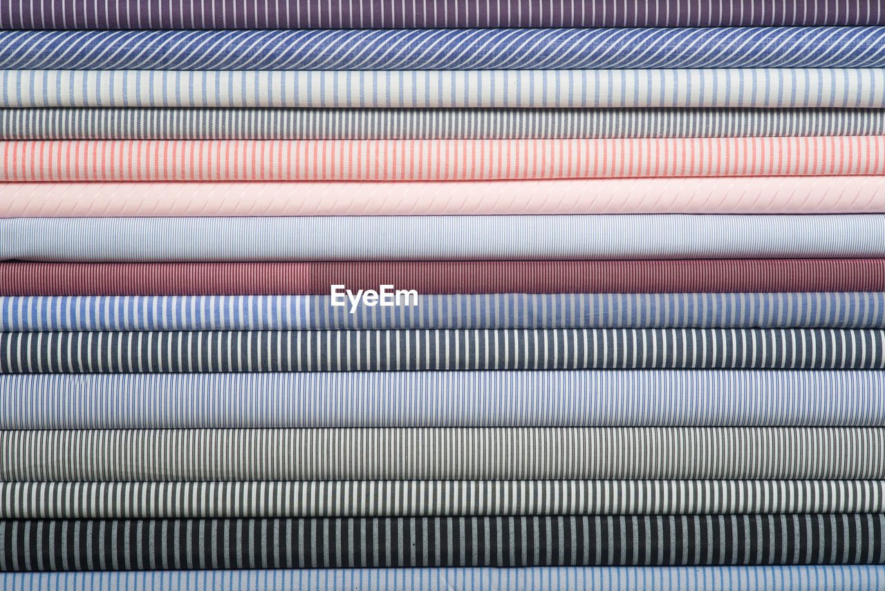Close-up of multi colored fabrics stacked in row
